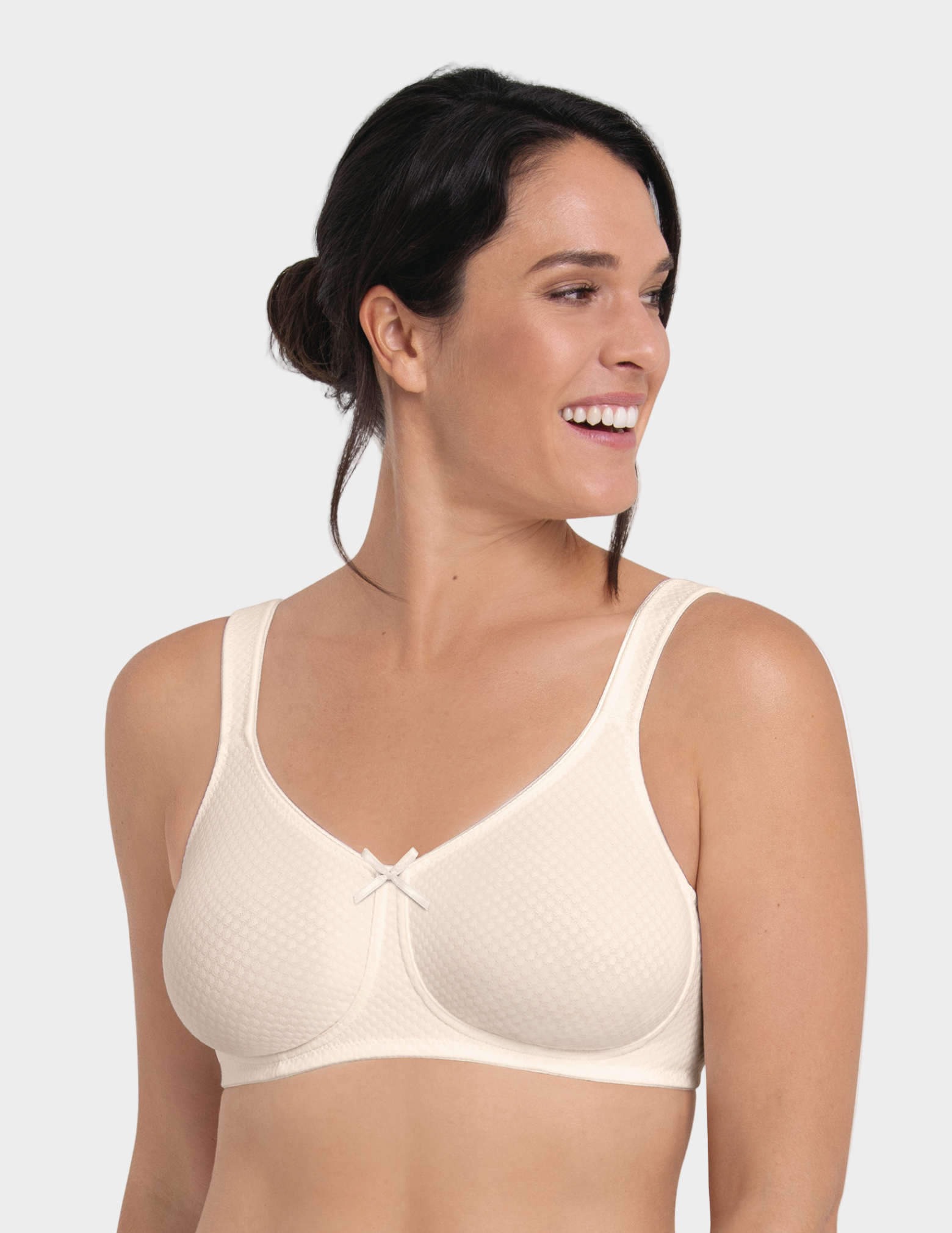 Woman wearing an off white bra against a white background