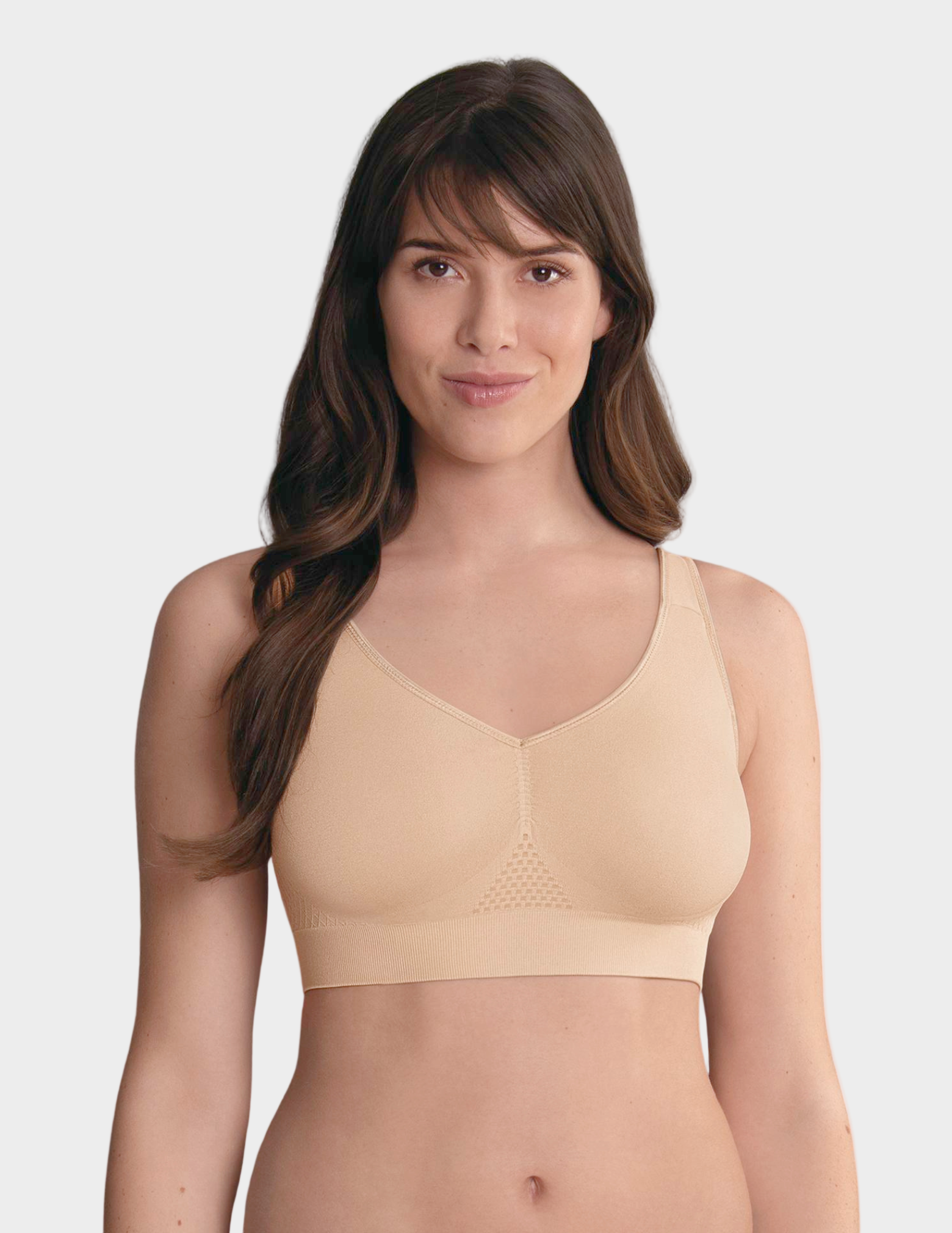 Woman wearing a beige bralette on a white background