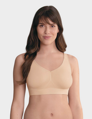Woman wearing a beige bralette on a white background