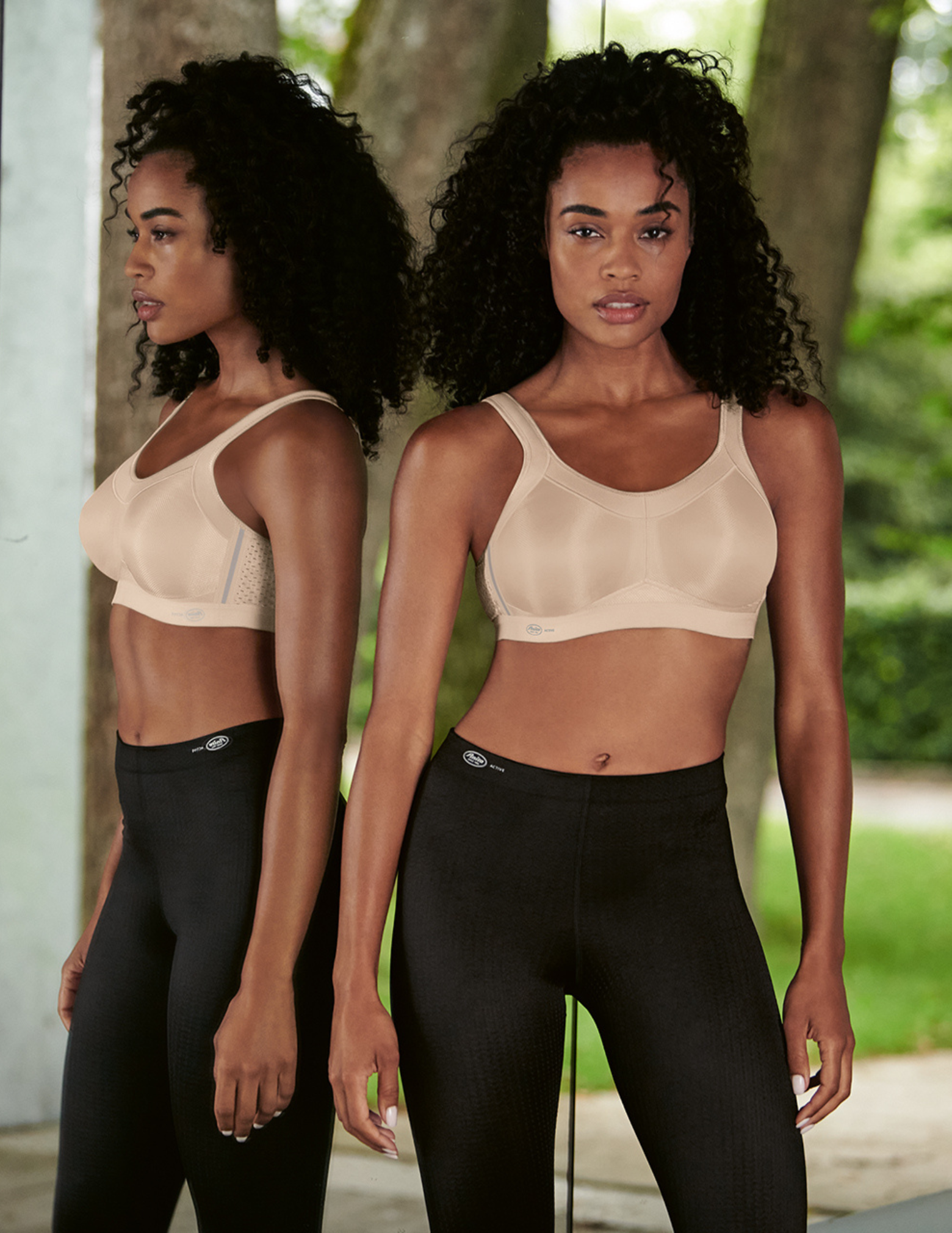 Woman wearing a beige sports bra and black leggings outdoors.