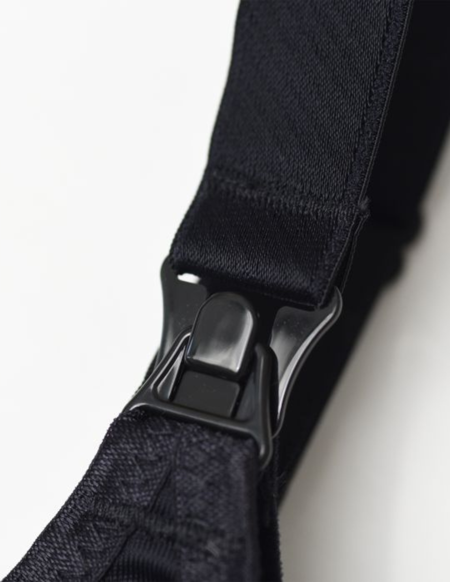 Close-up of a black nursing bra clip on a white background