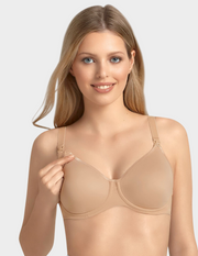 Woman wearing a beige nursing bra against a plain background