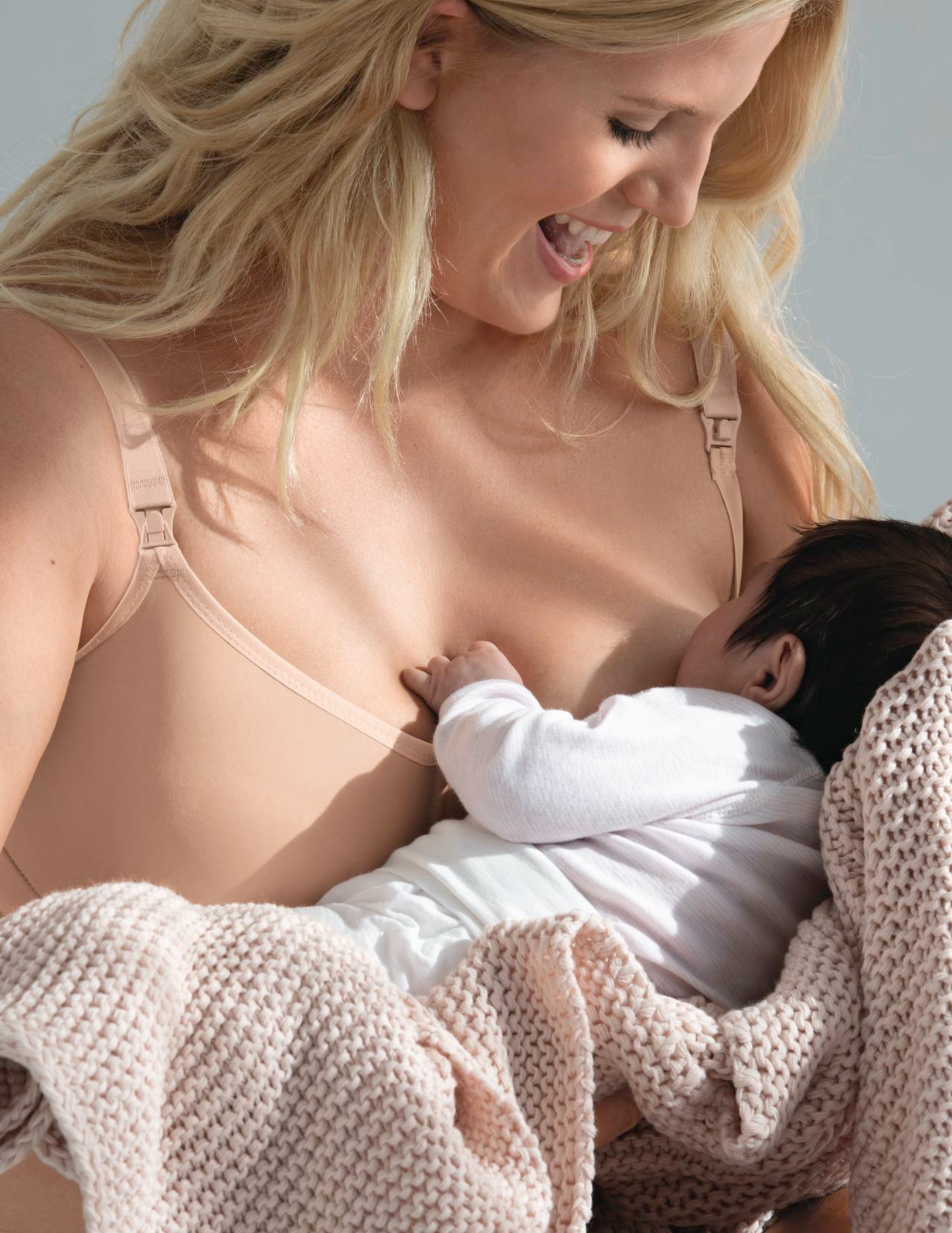 Woman breastfeeding a baby wrapped in a blanket