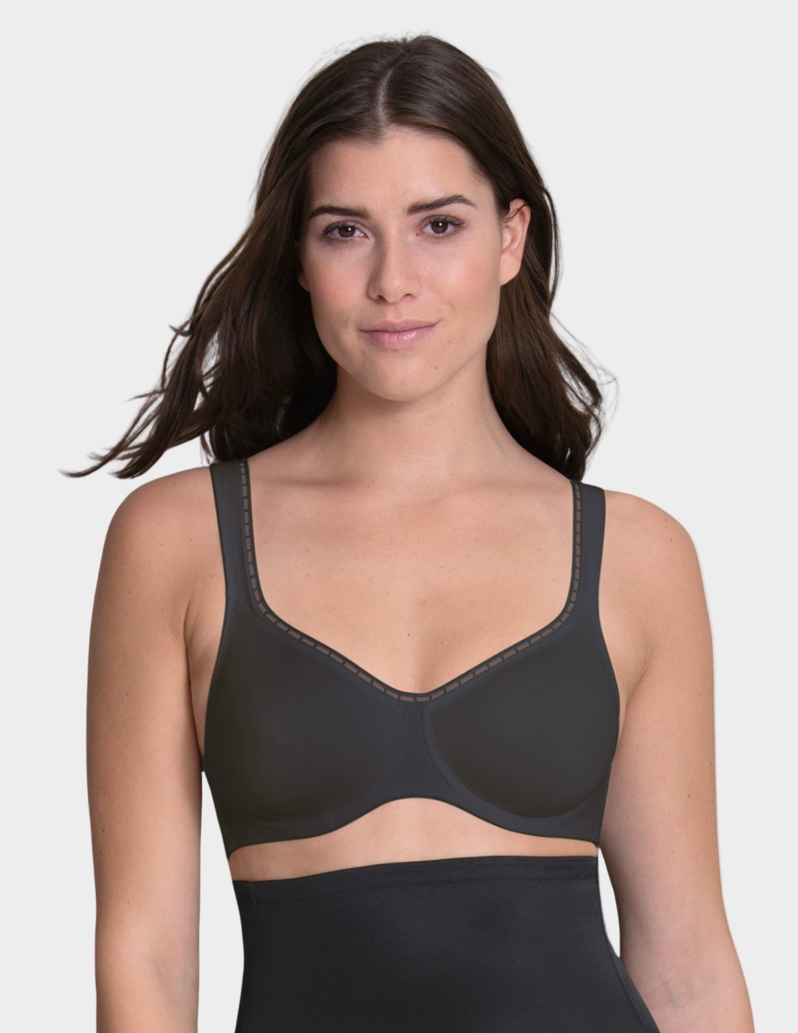 Woman wearing a black bra on a plain background