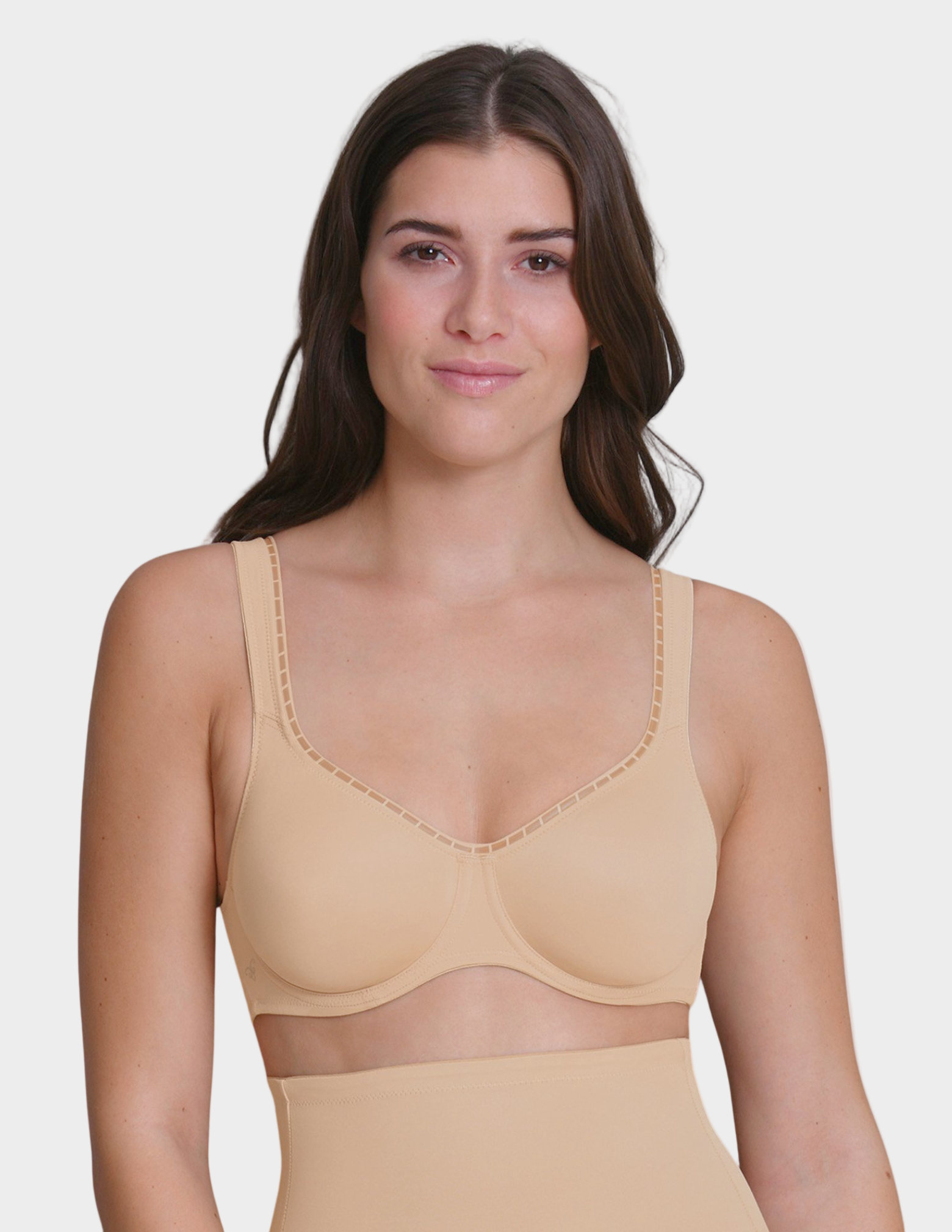 Woman wearing a beige bra on a plain background