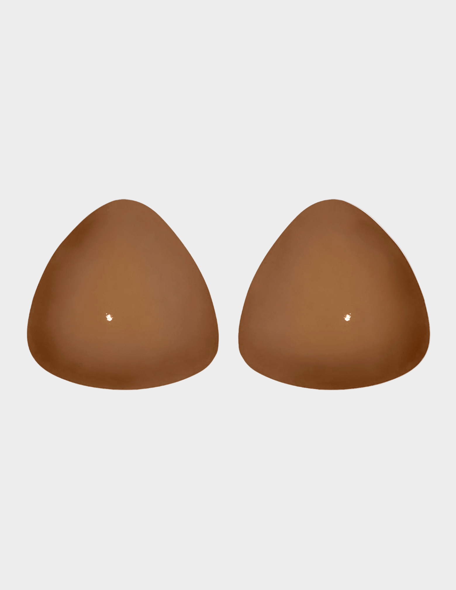 Pair of brown silicone bra cups on a white background