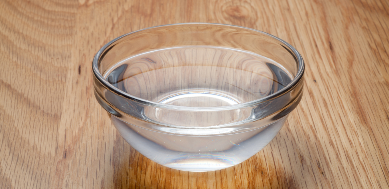 clear bowl of water on wood table