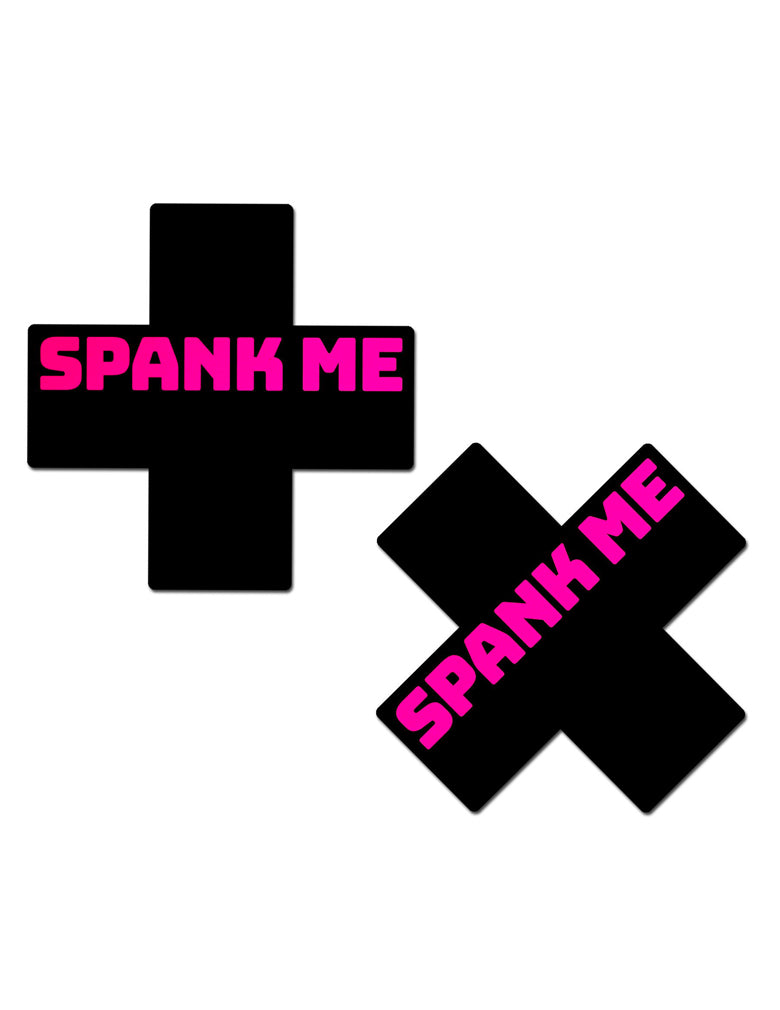 black X shaped nipple covers with pink text "spank me"