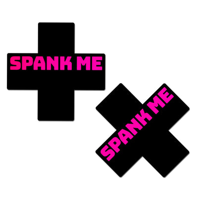 black X shaped nipple covers with pink text "spank me"
